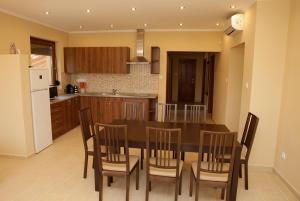 a kitchen with a dining room table and chairs at Boróka Vendégház in Szentes