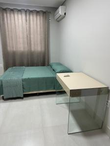 a bedroom with a bed with a desk and a window at Casa para 5 pessoas - Perto de Tudo in Montes Claros +18 photos