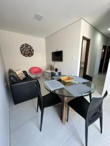 a living room with a table and chairs and a couch at Casa para 5 pessoas - Perto de Tudo in Montes Claros