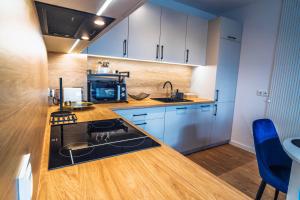 a kitchen with a sink and a stove in it at Morze Apartamentów Apartament West Łeba A19 in Łeba
