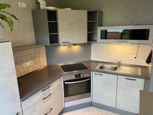 a small kitchen with white cabinets and a sink at Ferienwohnung Monteuerzimmer Melle in Melle +2 photos