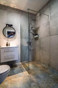 a bathroom with a shower and a toilet and a sink at Morze Apartamentów Apartament West Łeba A19 in Łeba +22 photos