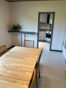 a dining room with a wooden table and a kitchen at Ferienwohnung Monteuerzimmer Melle in Melle