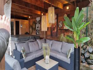 a living room with a couch and a potted plant at Holiday Home with bubble bath in Noordwijk in Noordwijk