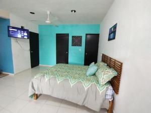 a bedroom with a bed and a blue wall at Departamento Centrico La Ria in Campeche