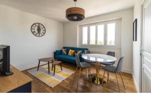 a living room with a blue couch and a table at TiArMor Saint-Brieuc Ville in Saint-Brieuc