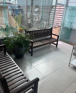 a balcony with a bench and a potted plant at Pousada Ohana Guarujá in Guarujá