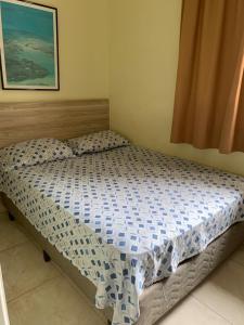 a small bed in a bedroom with a picture on the wall at Pousada Ohana Guarujá in Guarujá
