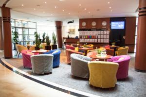 a restaurant with colorful chairs and tables in a lobby at Hotel Nadmorski in Gdynia