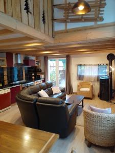 a living room with a leather couch and a table at Refuge chaleureux pour des vacances en famille in Le Lioran +4 photos