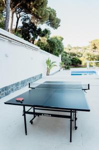 a ping pong table in front of a white wall at Casa Blanca in Dosríus