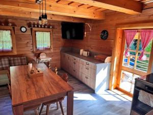 comedor con mesa y TV en una cabaña en Chatka pod orechom, en Terchová