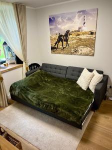 una camera da letto con un divano e un dipinto di un cavallo sul muro di Seaside apartment Albatross Home Resort Mēnesdārzs a Ķesterciems Altre 41 foto