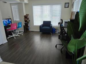 una oficina con silla, escritorio y TV en One Bed basement Room, en Brampton