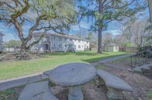 a stone table and benches in a yard at 20 Minute Walk to Tiger Stadium / King Bed in Beaulieu