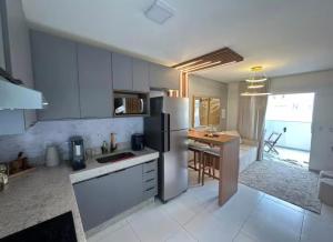 a kitchen with a refrigerator and a table in it at High Standard coral beach in Santa Cruz Cabrália