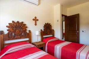 a bedroom with two beds and a cross on the wall at Los Amores 09 in Bucerías