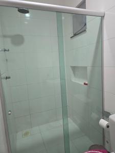 a glass shower door in a bathroom with a toilet at Suíte independente em condomínio privado in Ananindeua