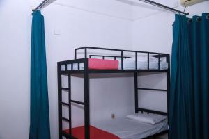 two bunk beds in a room with blue curtains at Stellar Bunks in Peradeniya