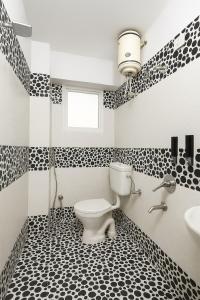 インドールにあるHomezype Homes Luxury Stayの黒と白のバスルーム(トイレ、シンク付)