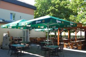 a group of tables and chairs with green umbrellas at Gasthof Huber in Wels