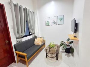 a living room with a blue couch and a window at Apartelle 386 in Dipolog