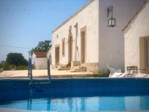 a house with a swimming pool in front of a building at Villa Nuova 1924 in Mottola