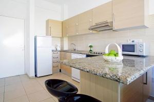 Una cocina con encimera con fregadero y microondas. en Too Coool Studio Apartment Coralli Resort, en Protaras