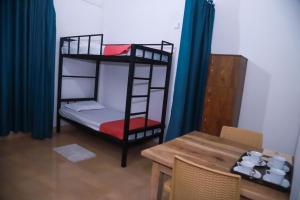 a room with two bunk beds and a table at Stellar Bunks in Peradeniya +1 photo