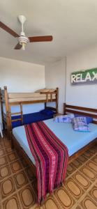 a bedroom with two bunk beds with a ceiling fan at Apto em Frente ao Mar - Prédio Redondo in Peruíbe