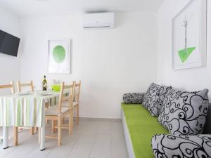 a living room with a table and a couch at Guest house Mazuth in Rab