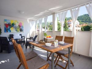 a dining room with a table and chairs and a window at Guest house Mazuth in Rab