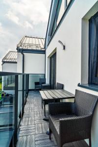a balcony with tables and chairs on a building at Morze Apartamentów Apartament West Łeba A20 in Łeba