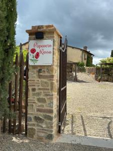 a gate with a sign on it next to a fence at PAPAVERO ROSSO in San Gimignano