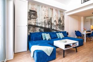 a living room with a blue couch and a table at Morze Apartamentów Apartament West Łeba A20 in Łeba +23 photos