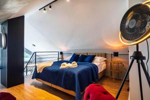 a bedroom with a blue bed and a fan at Morze Apartamentów Apartament West Łeba A20 in Łeba