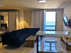a living room with a couch and a table at Luxury Suite with Jacuzzi on the beach by Almog Beach Haifa in Haifa +4 photos