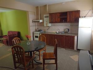 a kitchen with a table and chairs and a refrigerator at Alojamiento temporal - Alto Comedero in San Salvador de Jujuy
