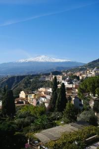 a city with snow covered mountains in the background at Casa Zàgará in Schisò