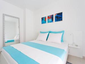 a white bedroom with a blue and white bed at Guest house Mazuth in Rab
