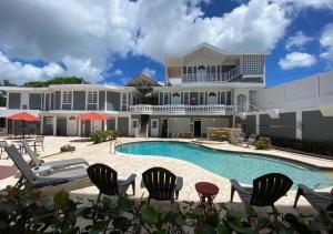 a large house with a swimming pool and chairs at The Village Inn in Carolina