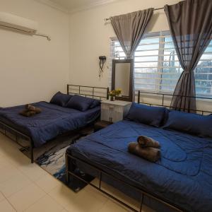 due letti in una stanza con lenzuola blu di GRANDE MAISON 1 Near A'famosa l Create l Uitm l Honda a Kampong Alor Gajah