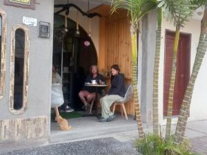 two people sitting at a table on a porch at Hostal Luren in Nazca +7 photos
