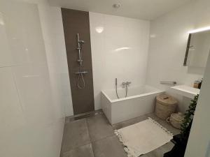 a white bathroom with a tub and a sink at Royal Touch Studio Brussels in Brussels