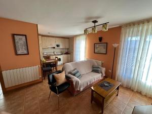 un soggiorno con un divano e un tavolo di APARTAMENTOS MATEO a Rillo de Gallo