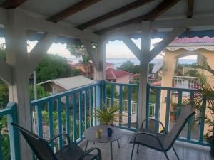 a porch with chairs and a table on a balcony at Le Goyavier in Saint-Pierre +15 photos