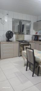 cocina con mesa, 2 sillas y barra en Cop30 Casa Barcarena, en Barcarena