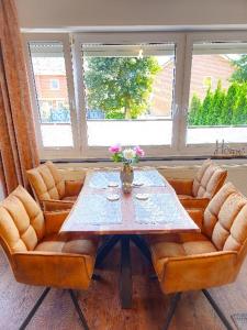メッペンにあるEcoCube 14 - 3 private Apartments, max 14 Gäste, 7 Betten, Terrasse, Gartenのテーブル(椅子2脚、花のテーブル付)