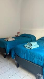 2 Betten mit blauer Bettwäsche in einem Zimmer in der Unterkunft Alojamiento por día La loma in Bahía Blanca