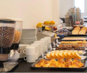 a buffet line with bread and pastries and plates of food at Hotel Ortegal in Mar del Plata